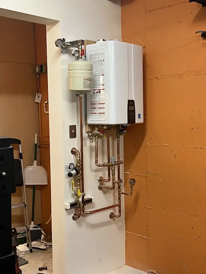 Plumbing technician inspecting water heater connections in Ontario
